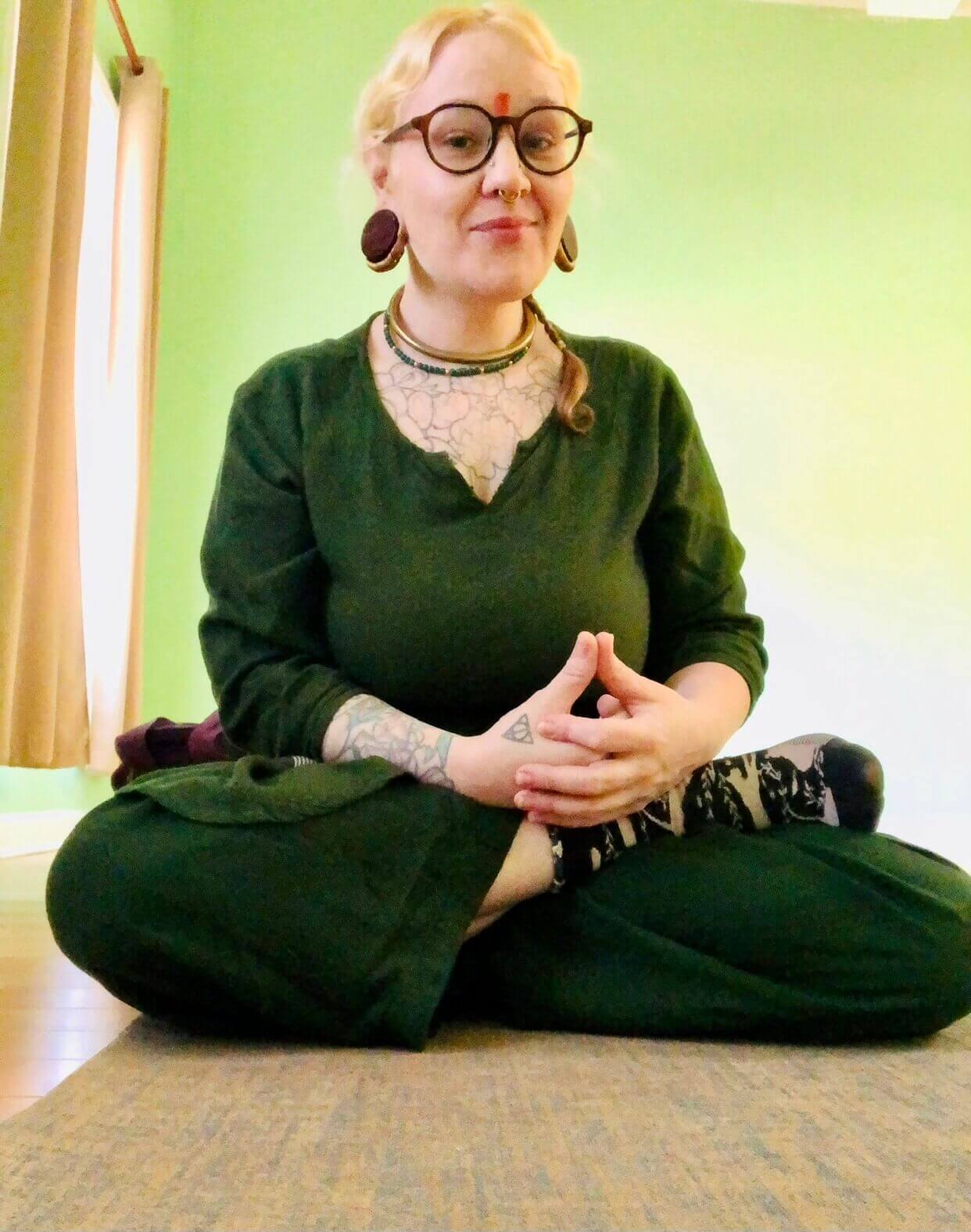 Person meditating cross-legged on a rug.
